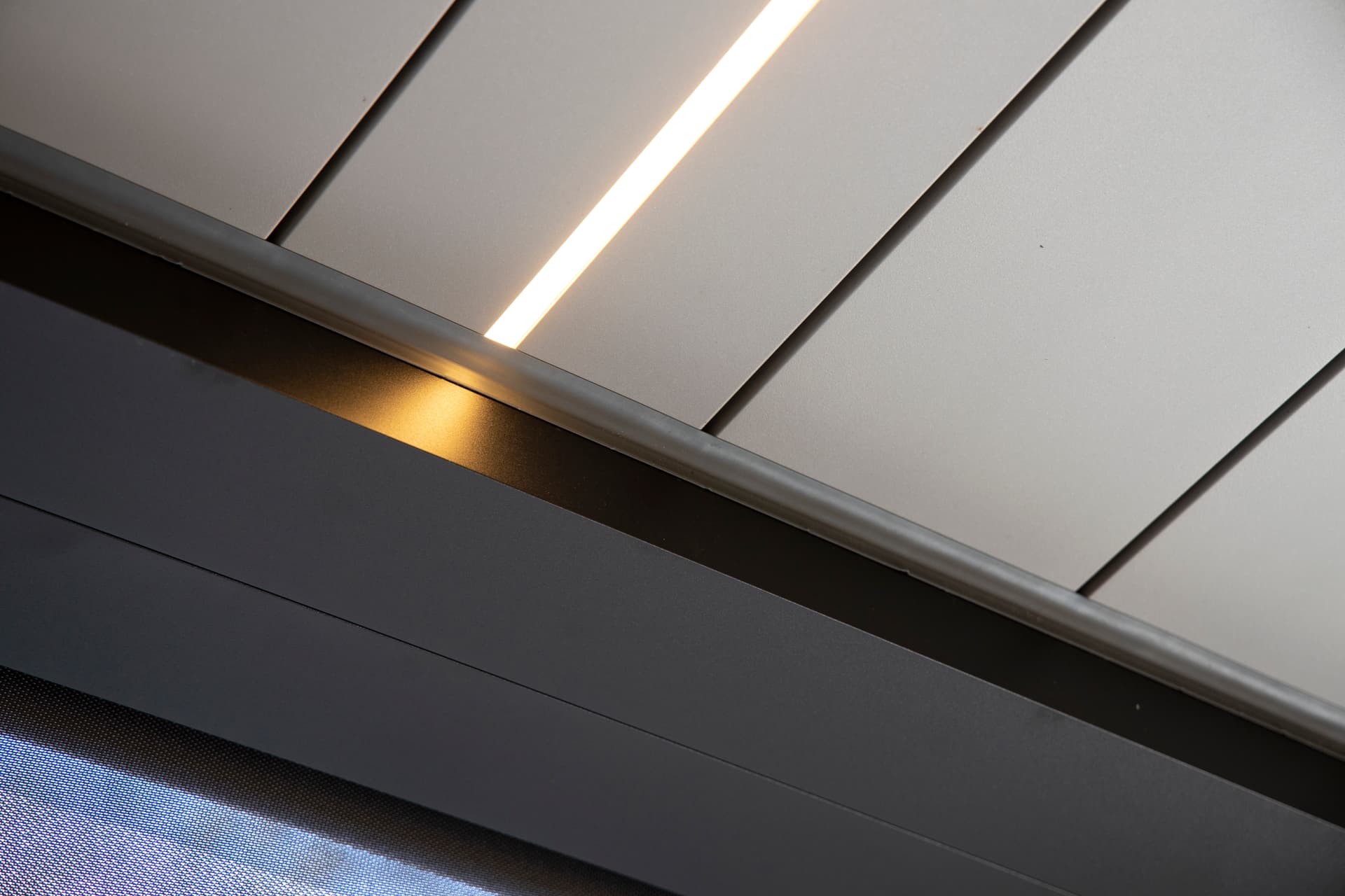 Close‑up van het lamellendak van een aluminium pergola met een geïntegreerde ledlichtlijn tussen de lamellen.
