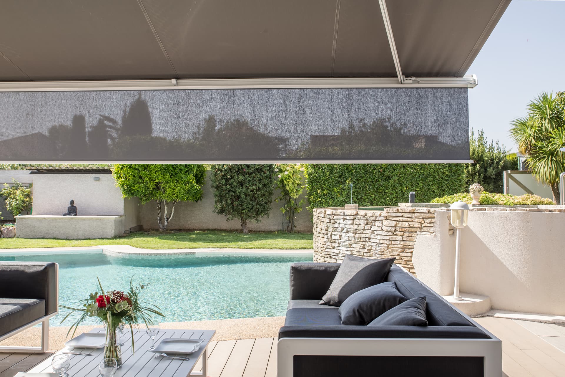 Uitschuifbare volant aan een Brustor‑zonnescherm die extra bescherming biedt tegen laagstaande zon en schaduw creëert aan een modern zwembadterras