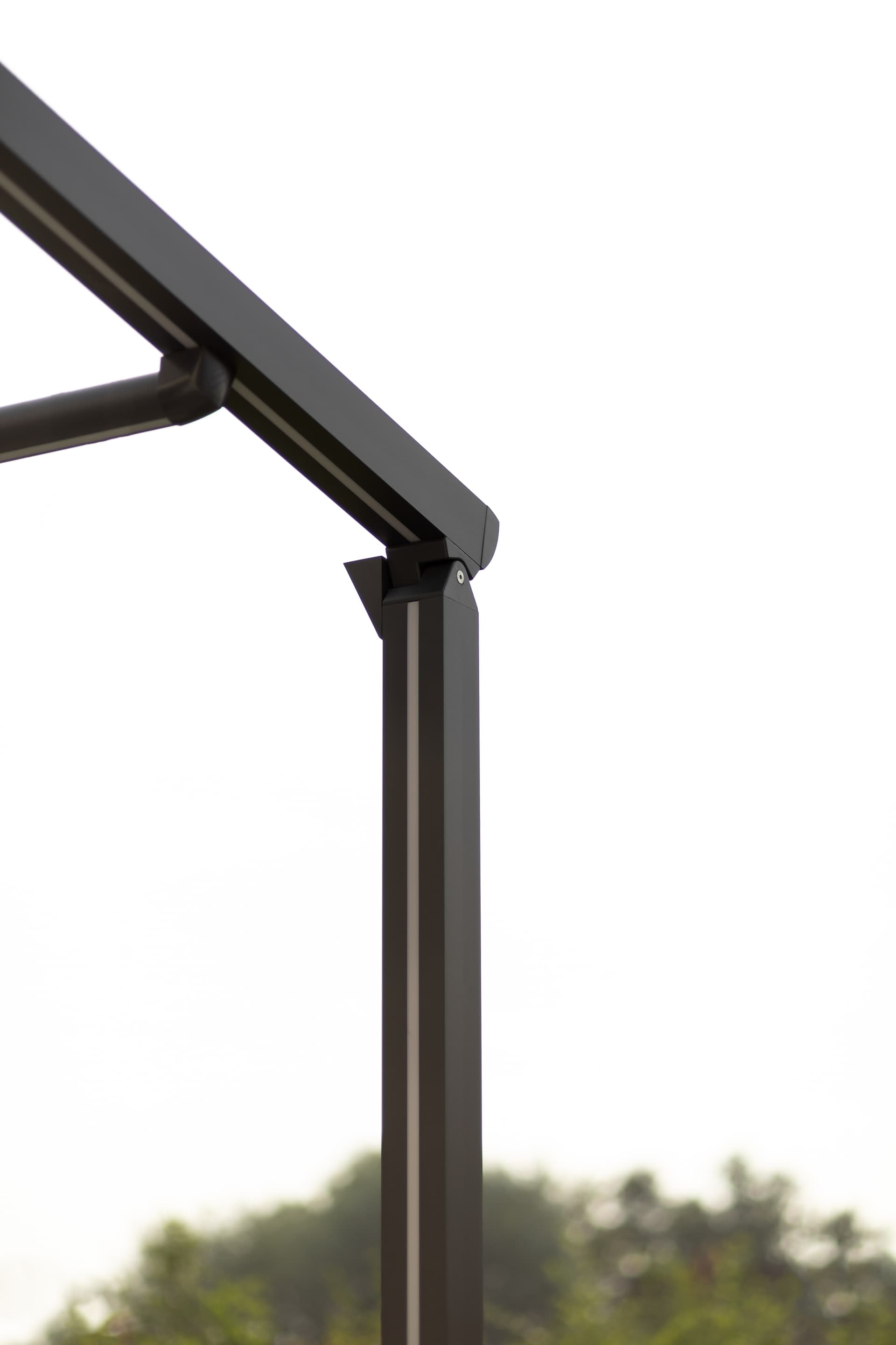 Close‑up van de aluminium pergolaconstructie met het strakke scharnierpunt van het oprolbare doekdak in een modern ontwerp