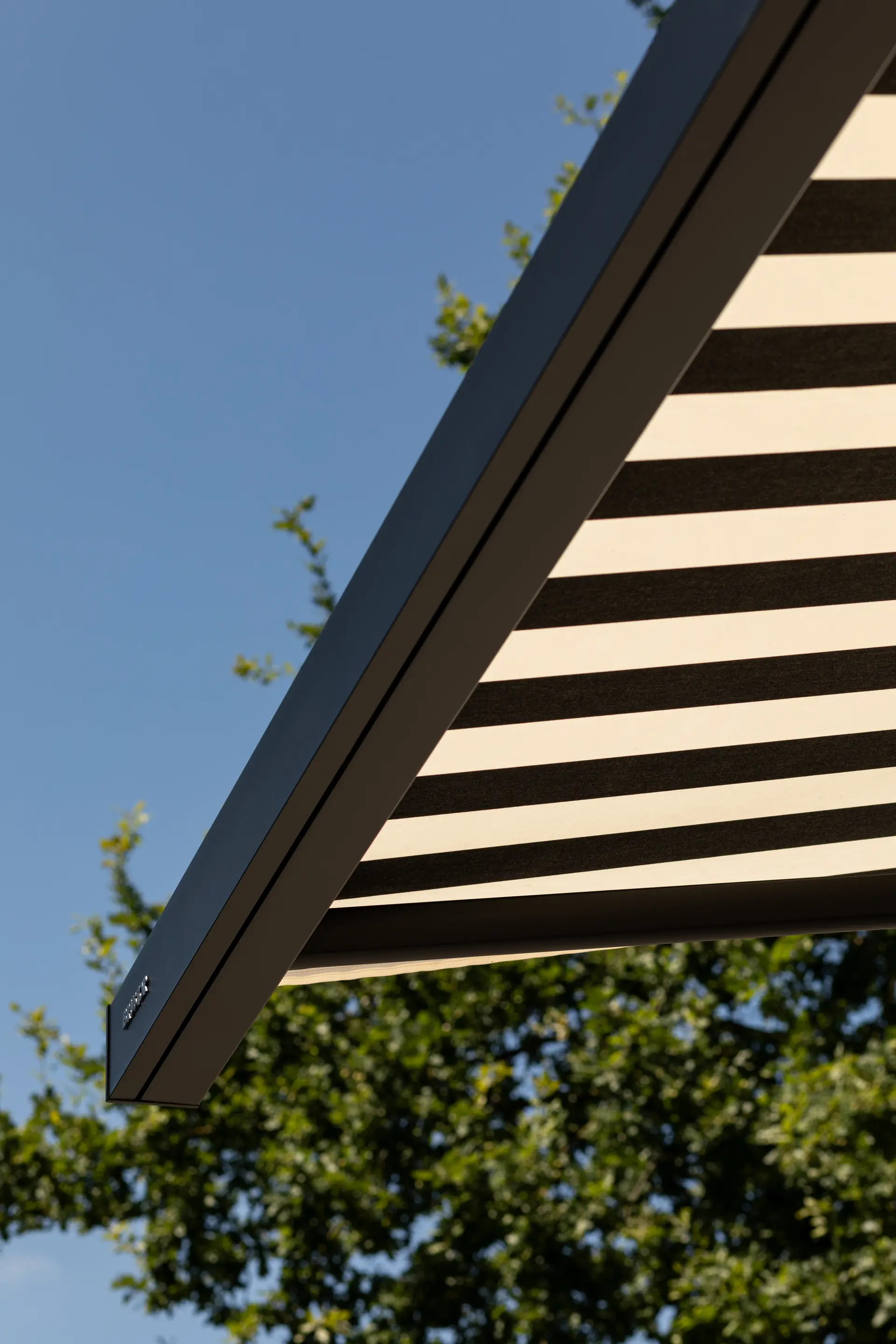 Close‑up van een infrarood terrasverwarmer, gemonteerd onder een aluminium pergolaconstructie.