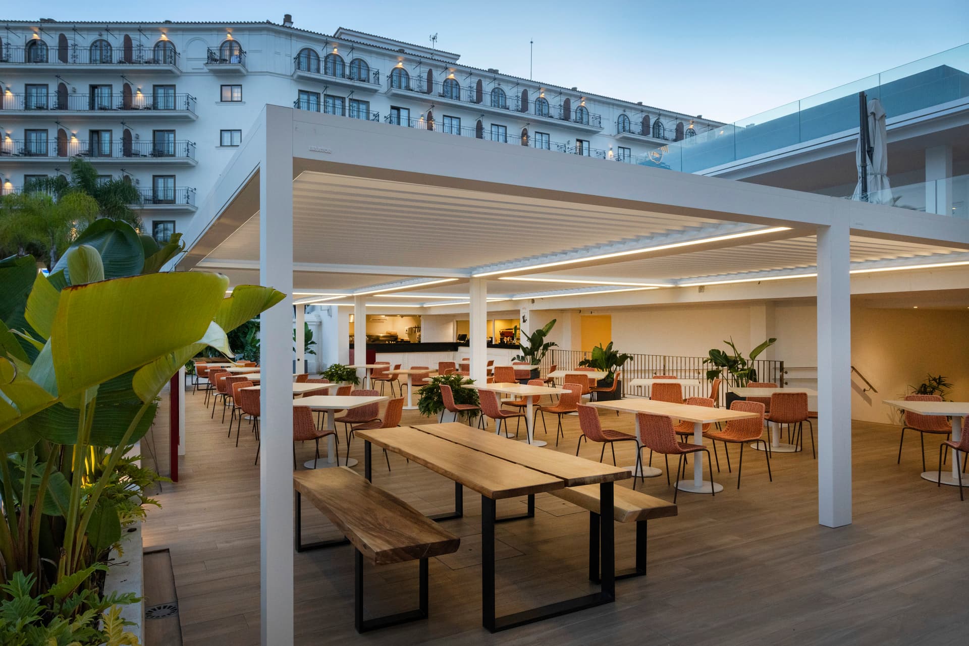 Aluminium louvred roof pergola in light finish installed above contemporary outdoor dining area