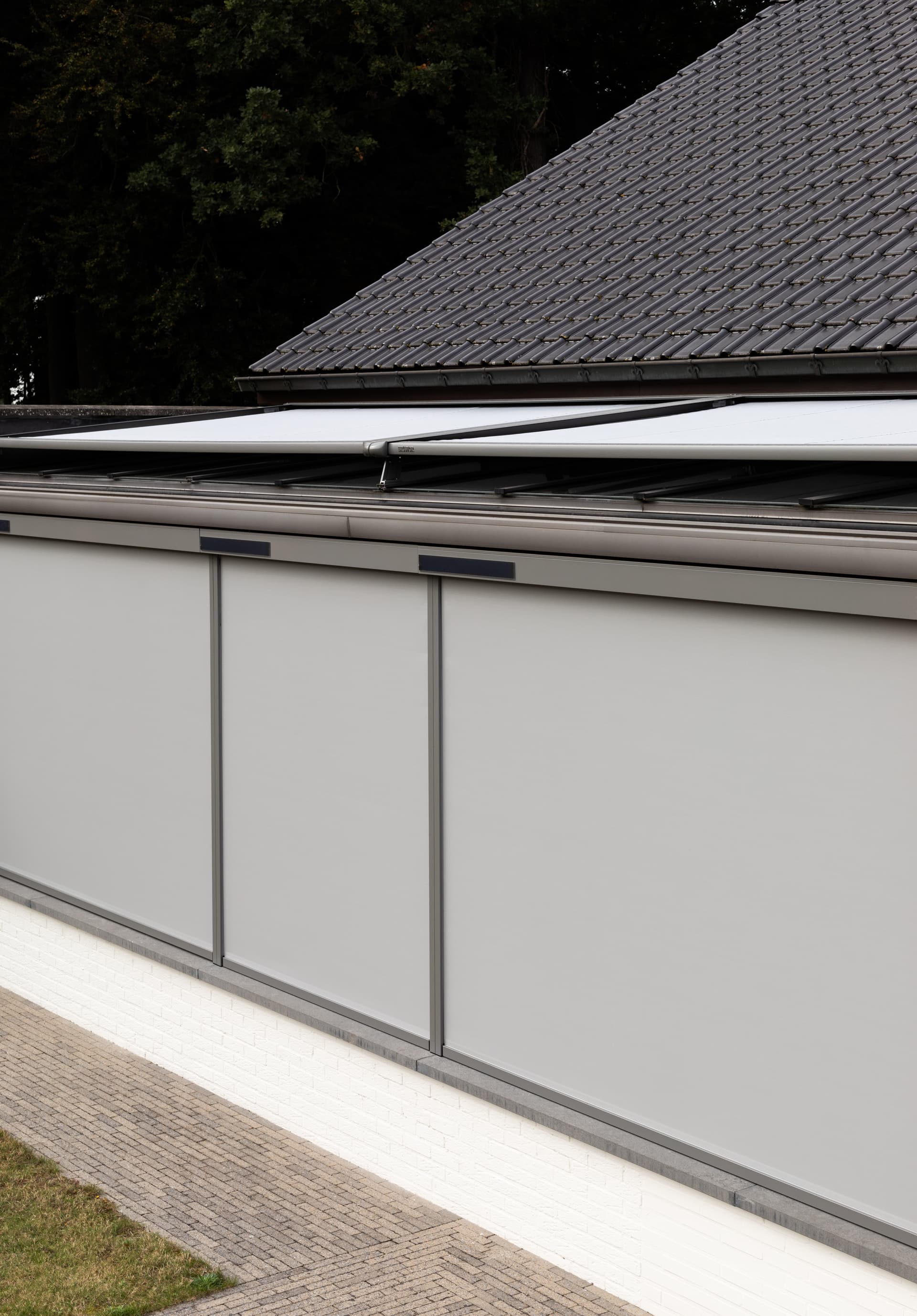 Brustor B126 verandazonwering gecombineerd met verticale ZIP‑screens op een glazen veranda voor buitenzonwering en privacy